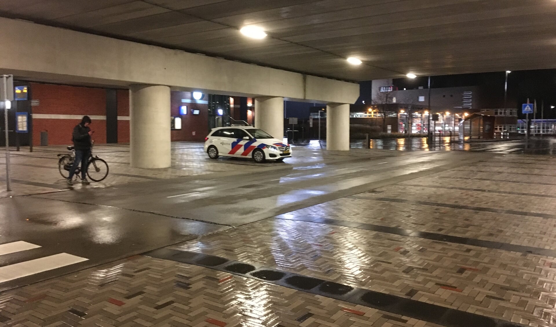 Politiewagen op het stationsplein tijdens het begin van de avondklok