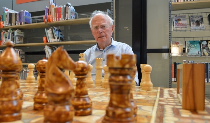 Onno Wolters met het schaakspel in de bibliotheek.