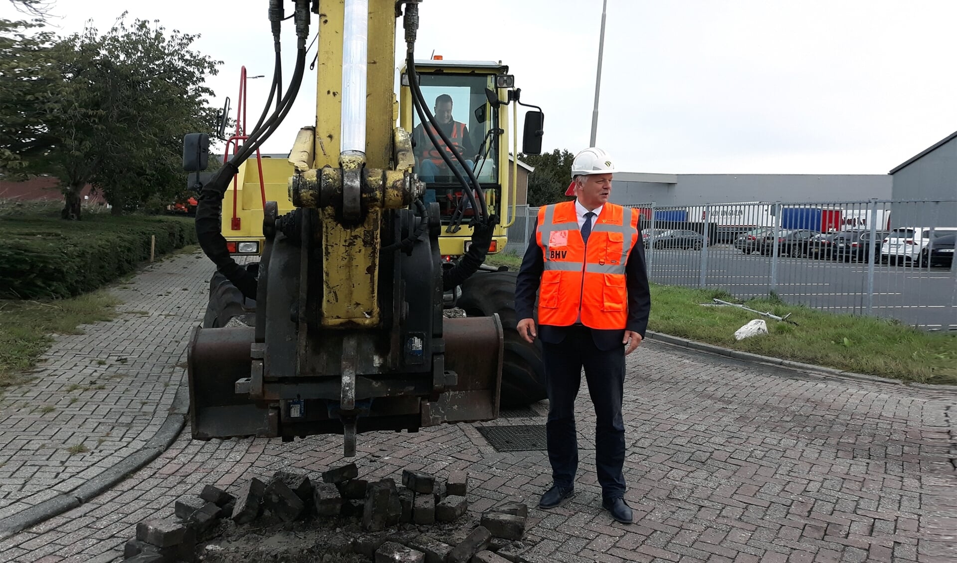 Wethouder Holtland bij de eigenhandig verwijderde straatklinkers