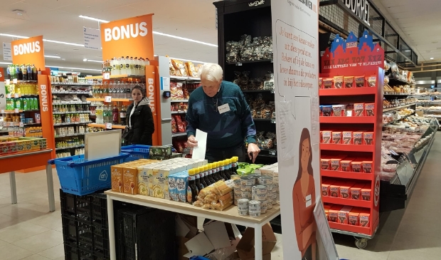 Een vrijwilliger van de voedselbank bij de Albert Heijn.