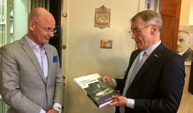De overhandiging va het boek door Herman Harder aan de grote baas van de Volksbank, Martijn Gribnau.