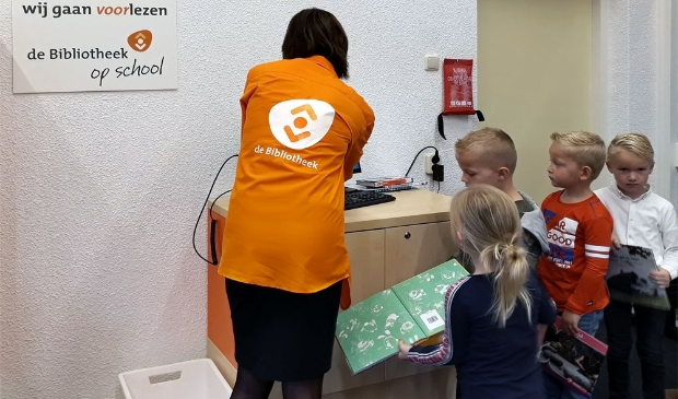 <p>Leerlingen van SmdB 'Het Visnet' staan in de rij bij leesconsulente Marjan Albers </p>