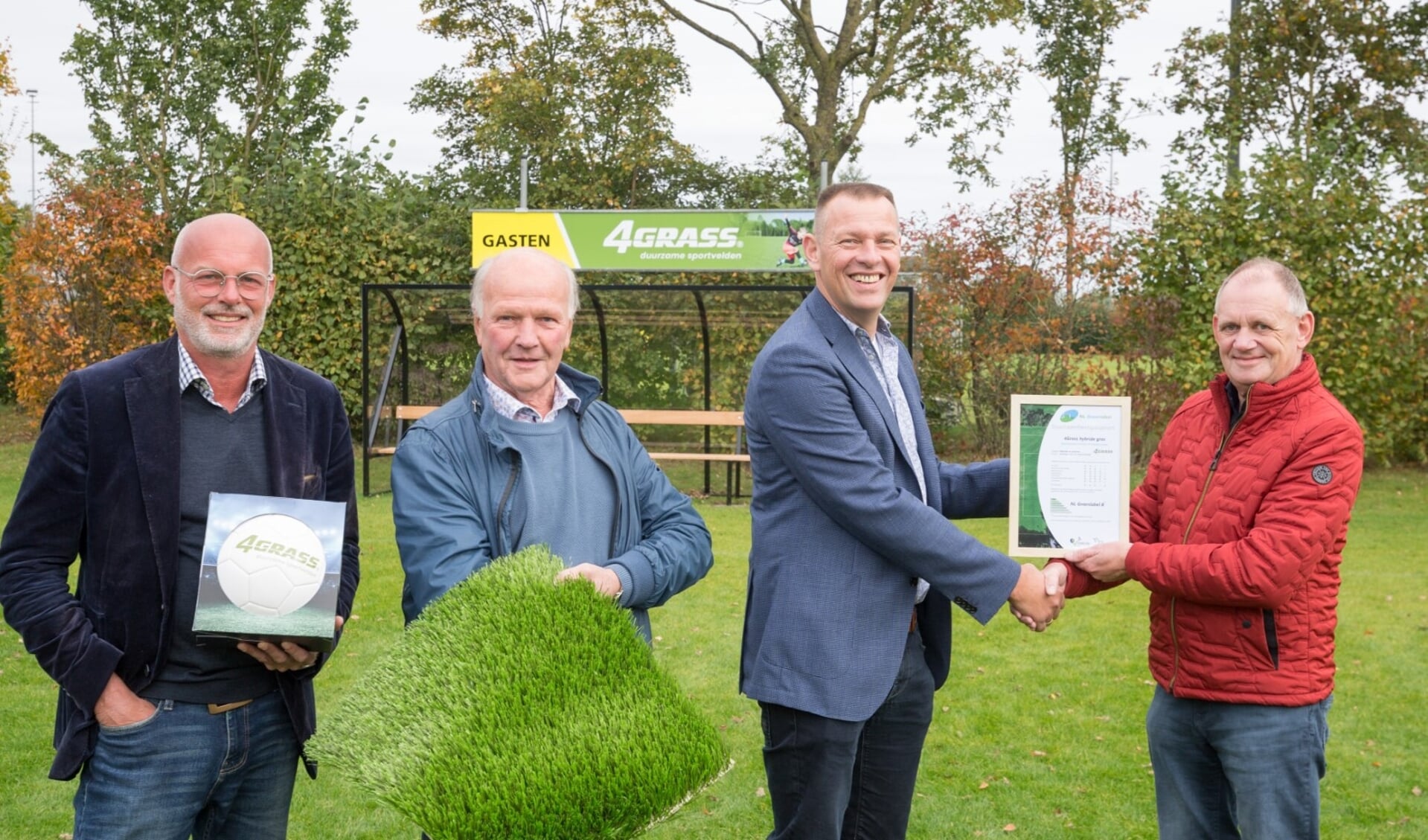 Voorzitter Ben Schreurs (r) van VSCO'61 neemt het duurzaamheidspaspoort NL Greenlabel B voor de hybride velden in ontvangst