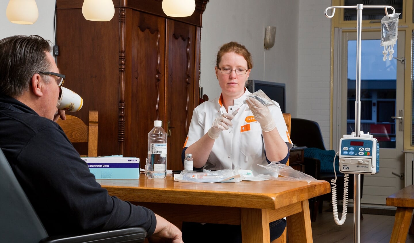 Een oncologie verpleegkundige van Icare geeft een patiënt thuis immuuntherapie. 