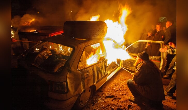 Vuurspuwers op het Markeresplein in IJsselmuiden steken twee auto's in brand nadat er eerst flink mee gescheurd werd. Foto Freddy Schinkel. Datum: 31 december 2004