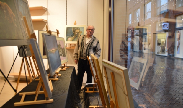 Aad Gordijn bij zijn werk in de etalage van Miss Etam.