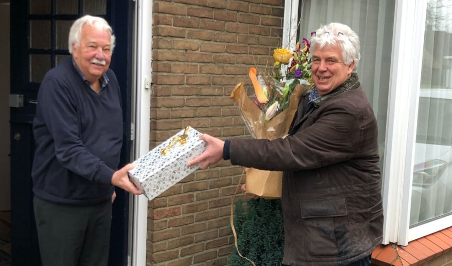 Ton ter Bekke (l) ontvangt uit handen van voorzitter Rinke Beverwijk een bos bloemen en een kistje wijn.
