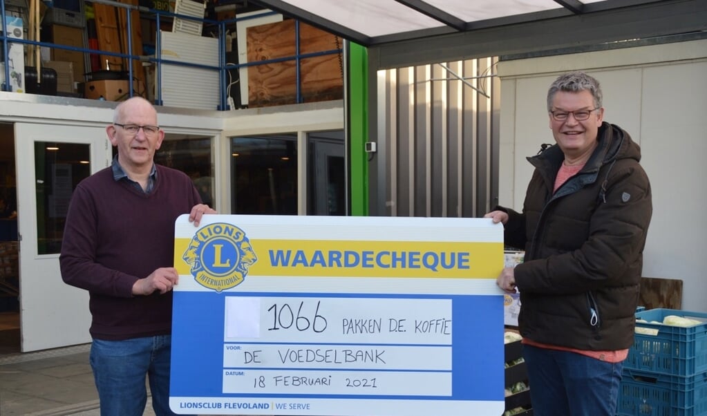 Dick van Tilburg overhandigt de cheque aan Jan Groenendijk van de voedselbank.
