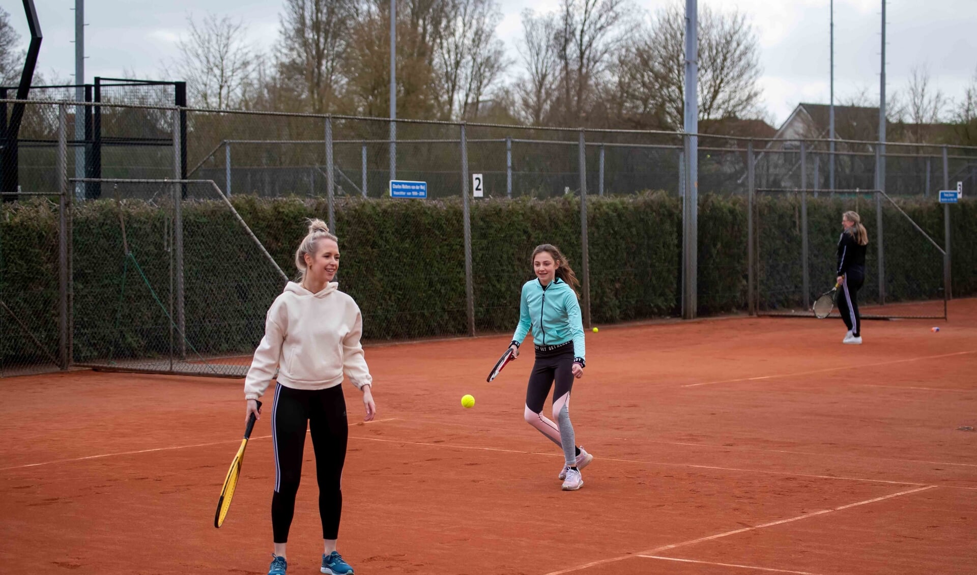 Twee deelnemers genieten van hun kennismaking met tennis bij KJLTC. 