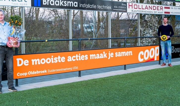 Hans Vlaar (l) en Sjoerd Kwakkel bij het nieuwe reclamebord op sportpark De Heughte