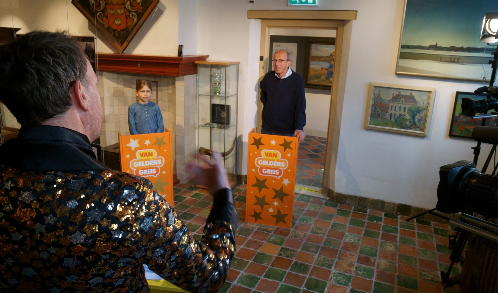 Vrijwilliger Duco Schotborgh en zijn kleinkind Koen beantwoorden vragen tijdens de ‘grootouder-kleinkind quiz’. Quizmaster Jochem van Gelder stelt hun kennis op de proef.