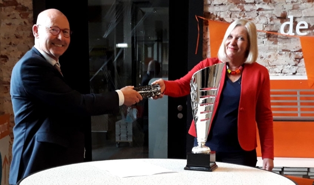 <p>Bort Koelewijn overhandigt de luxe pennenset aan Margriet Roukema met voor zich de wisselbeker voor de teams</p>
