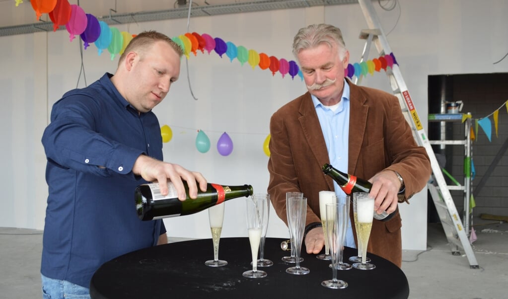 Tommy Dunnik en Henk Potgieter schenken champagne in het in aanbouw zijnde MFG.