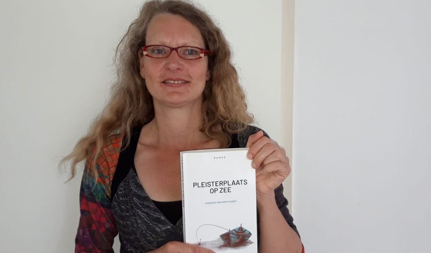 Marjan van der Harst met haar roman 'Pleisterplaats op Zee'.