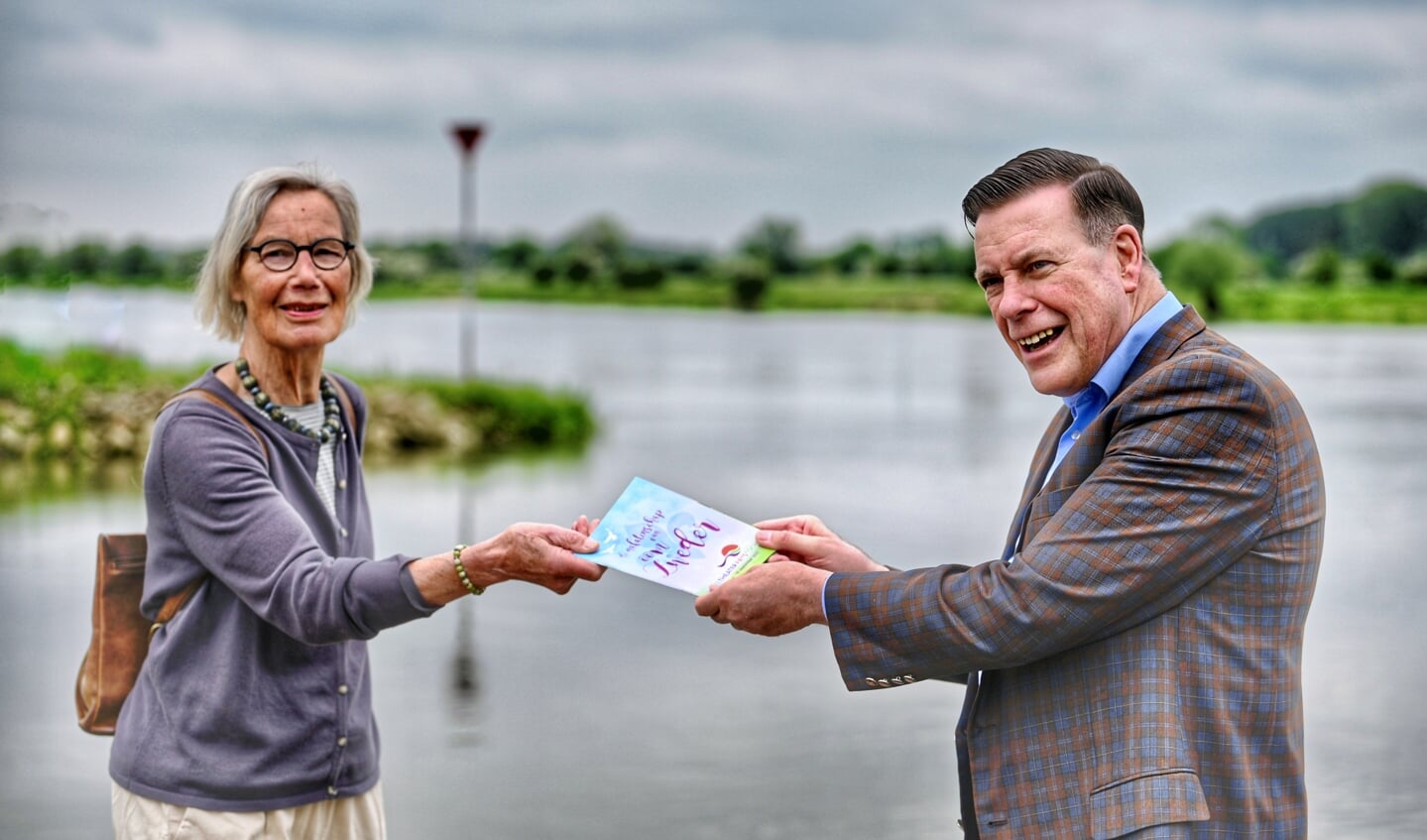 Marleen Brokmeier (bestuurslid IJTFT) overhandigt het eerste routeboekje aan burgemeester Ton Strien van de gemeente Olst-Wijhe