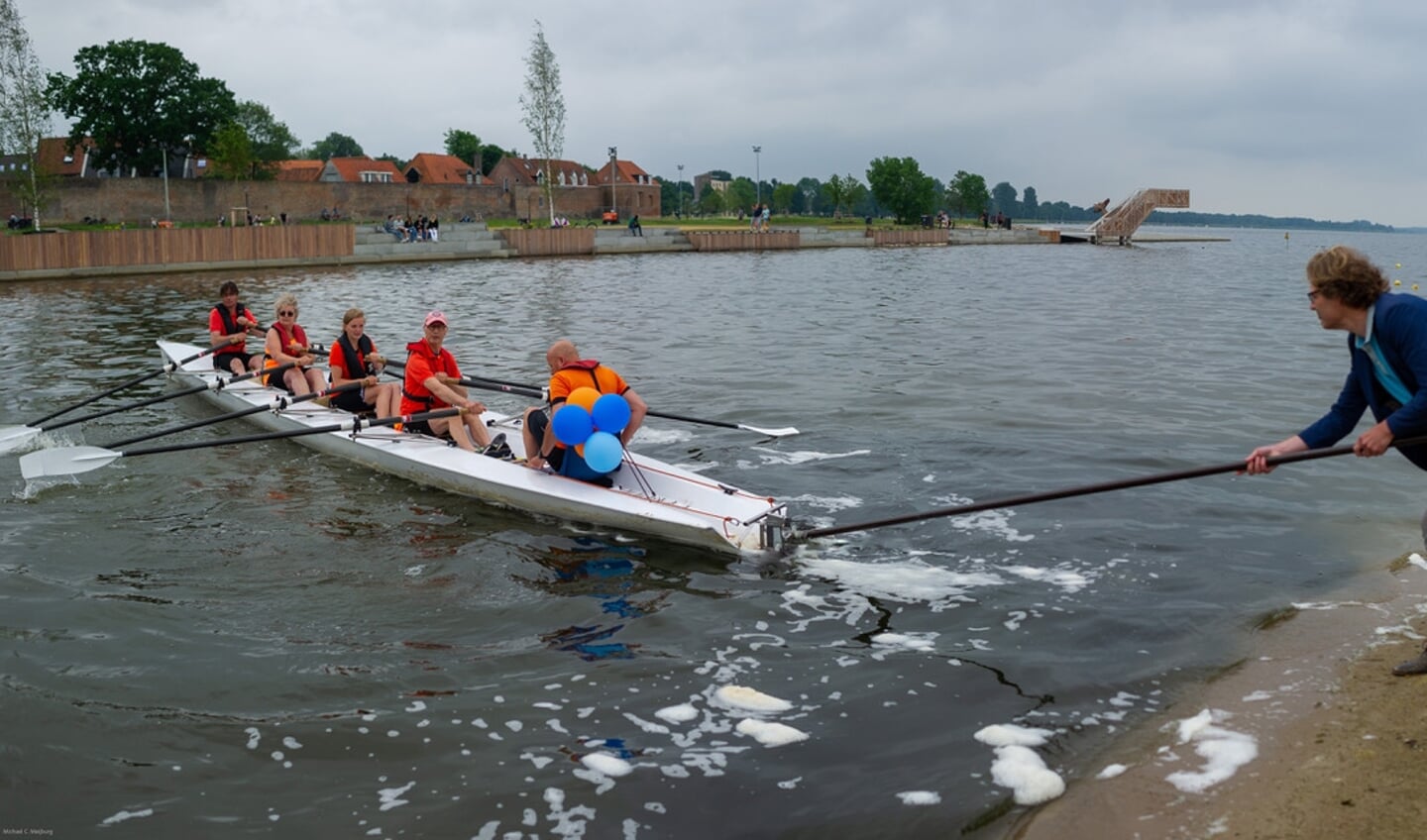 Wethouder Marcel Companjen (Sport) duwt de eerste boot van RV Harder af, als een symbolische start van de nieuwe roeivereniging