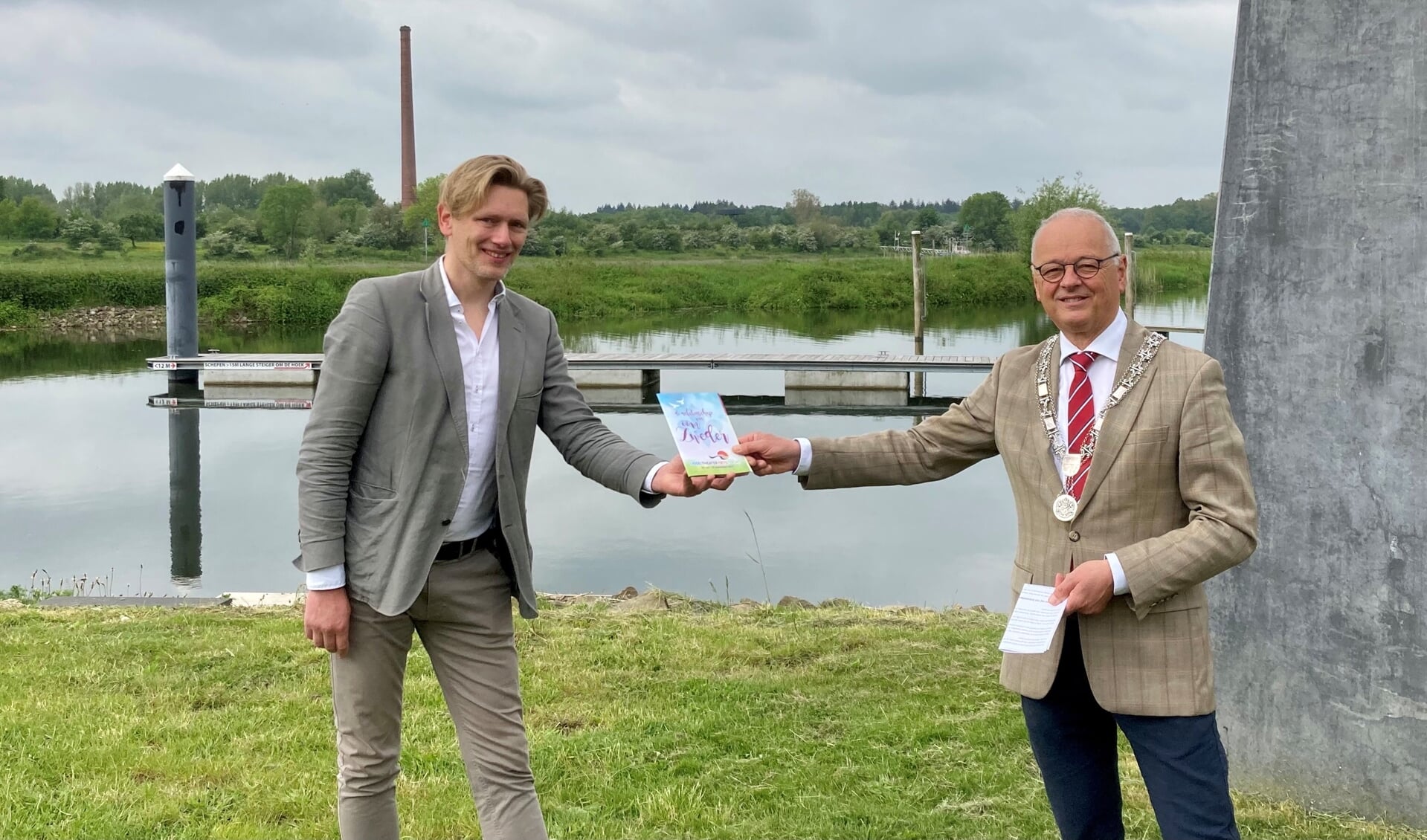 Bij de haven in Veessen ontving burgemeester Wiggers van gemeente Heerde het boekje