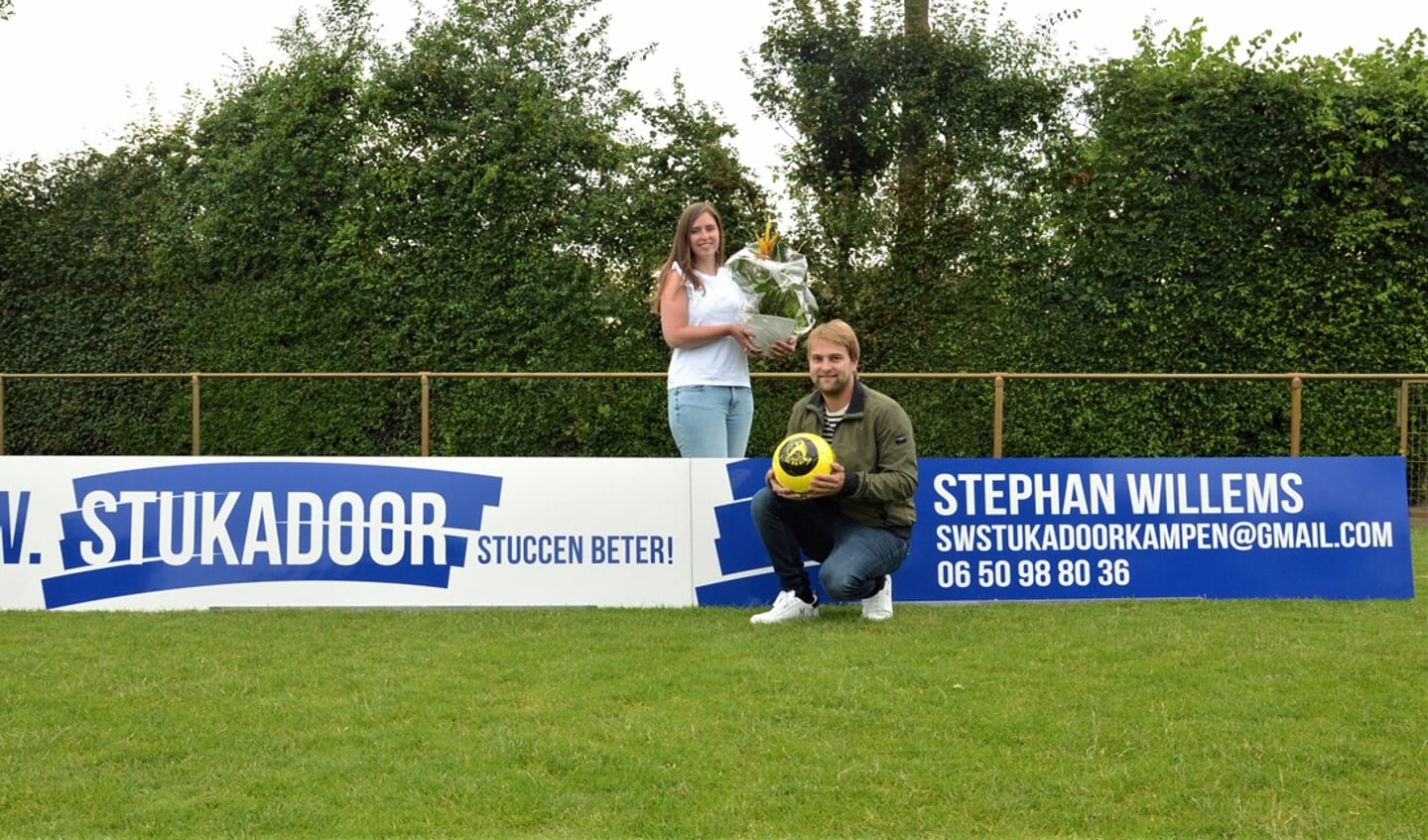 Jeanette Wessels en Stefan Willems van SW Stukadoor bij het nieuwe reclamebord op sportpark De Heughte van VSCO'61