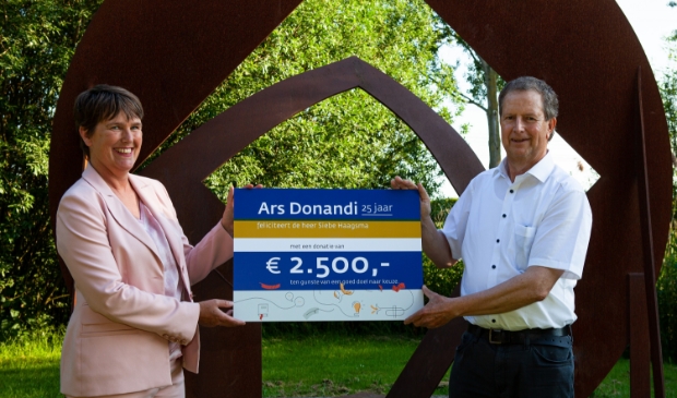 <p>Magdeleen Sturm overhandigt de cheque aan Siebe Haagsma.</p>