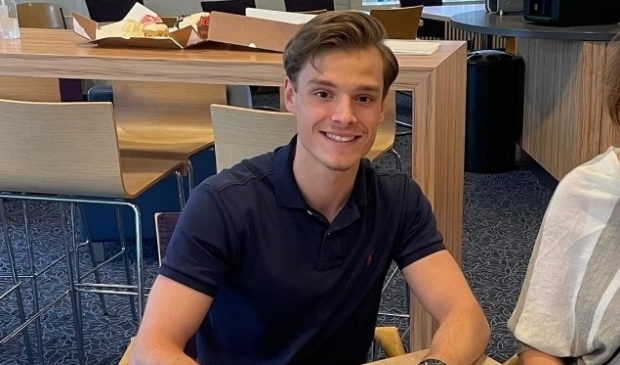Xander Bliek ondertekent zijn vwo-diploma.