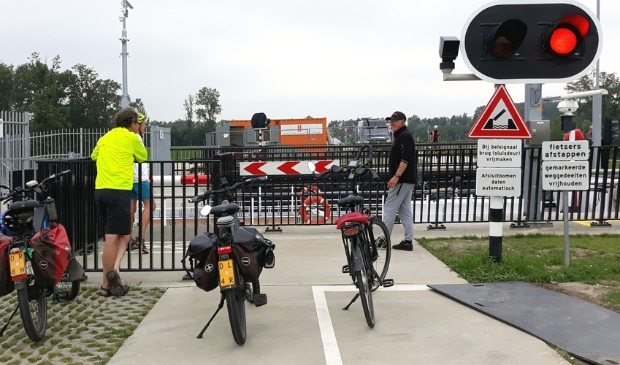 <p>Fietsers ontmoeten elkaar bij de geopende sluis</p>