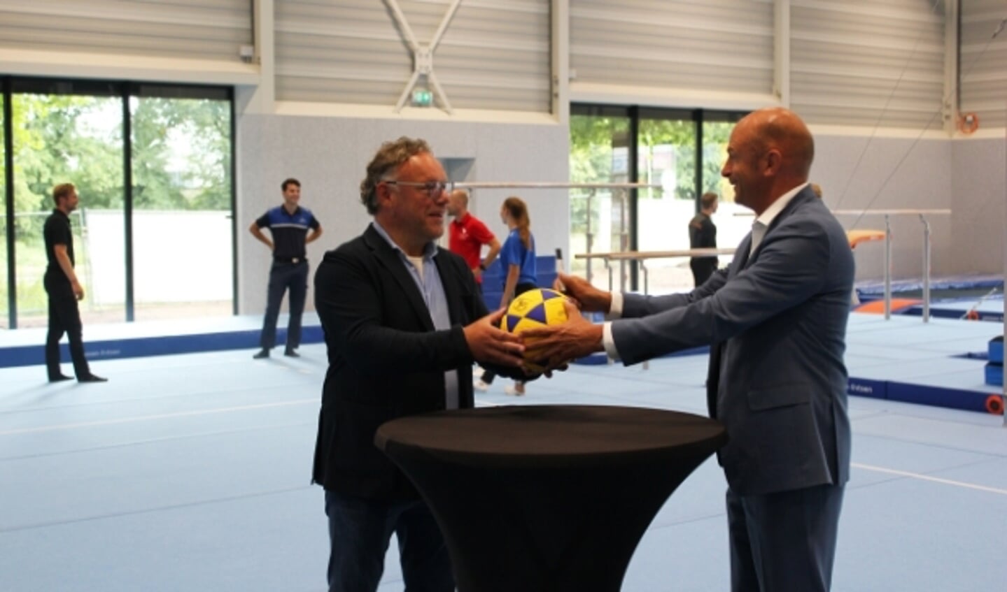 Theo Rietkerk (Landstede Groep) overhandigt de gesigneerde bal aan Gerrit Janssen.