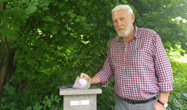 Dries Jonker staat bij de sokkel waar voorheen zijn beeld opstond. In zijn hand de afbeelding van zijn prachtige beeld van de kikker.