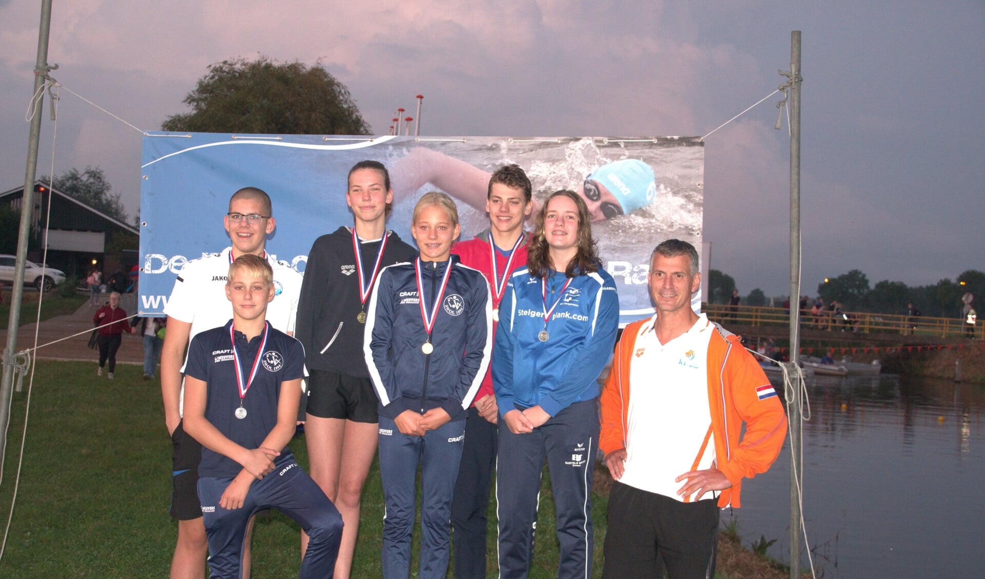 Links vooraan Storm Boxum en naast hem zusje Fay. Met andere medaillewinnaars van het OC Drachten en, rechts, trainer Henri Koek.