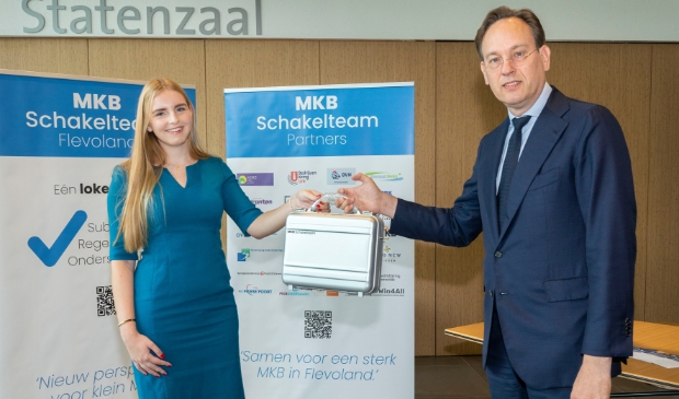 Suzan de Jongste ontvangt de ambassadeurskoffer van de gedeputeerde.