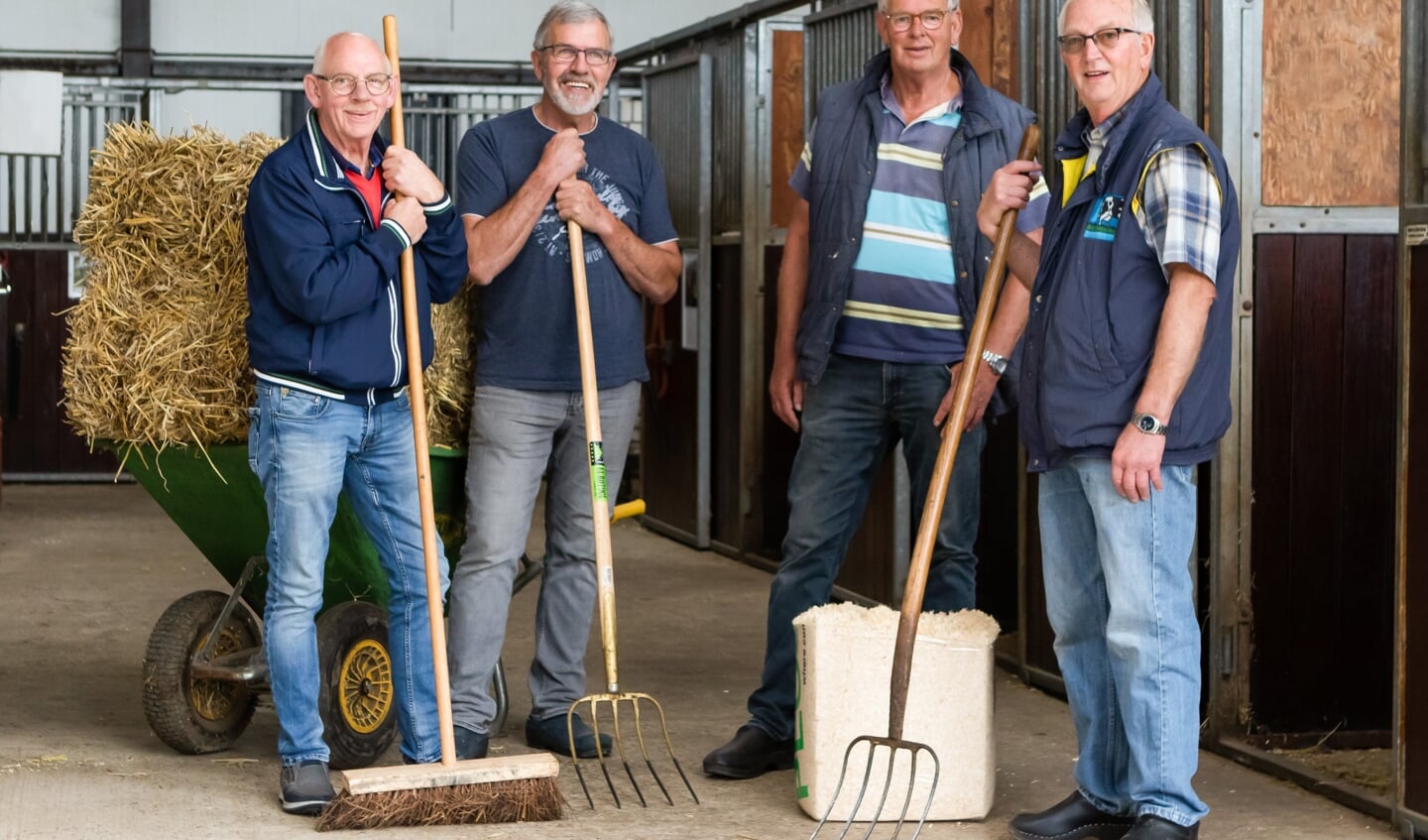 Vrijwilligers die stallen uitmesten bij de SPGIJ.