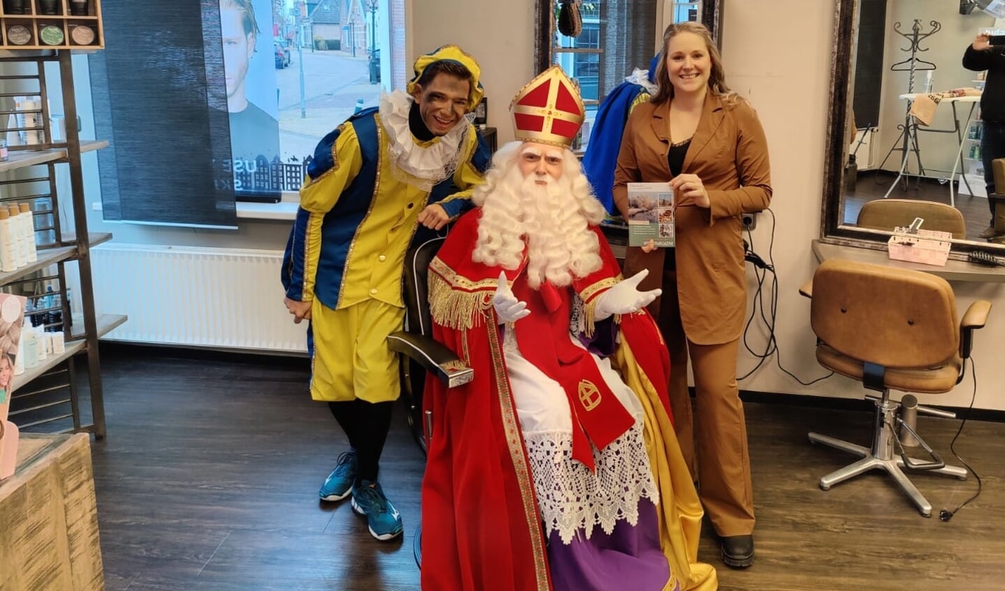 Majell Boelens biedt Sinterklaas het Wintermagazine aan