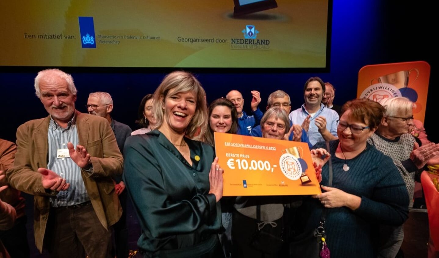 Een lachende Rinette van der Vliet is enorm blij met de cheque van 10.000 euro.