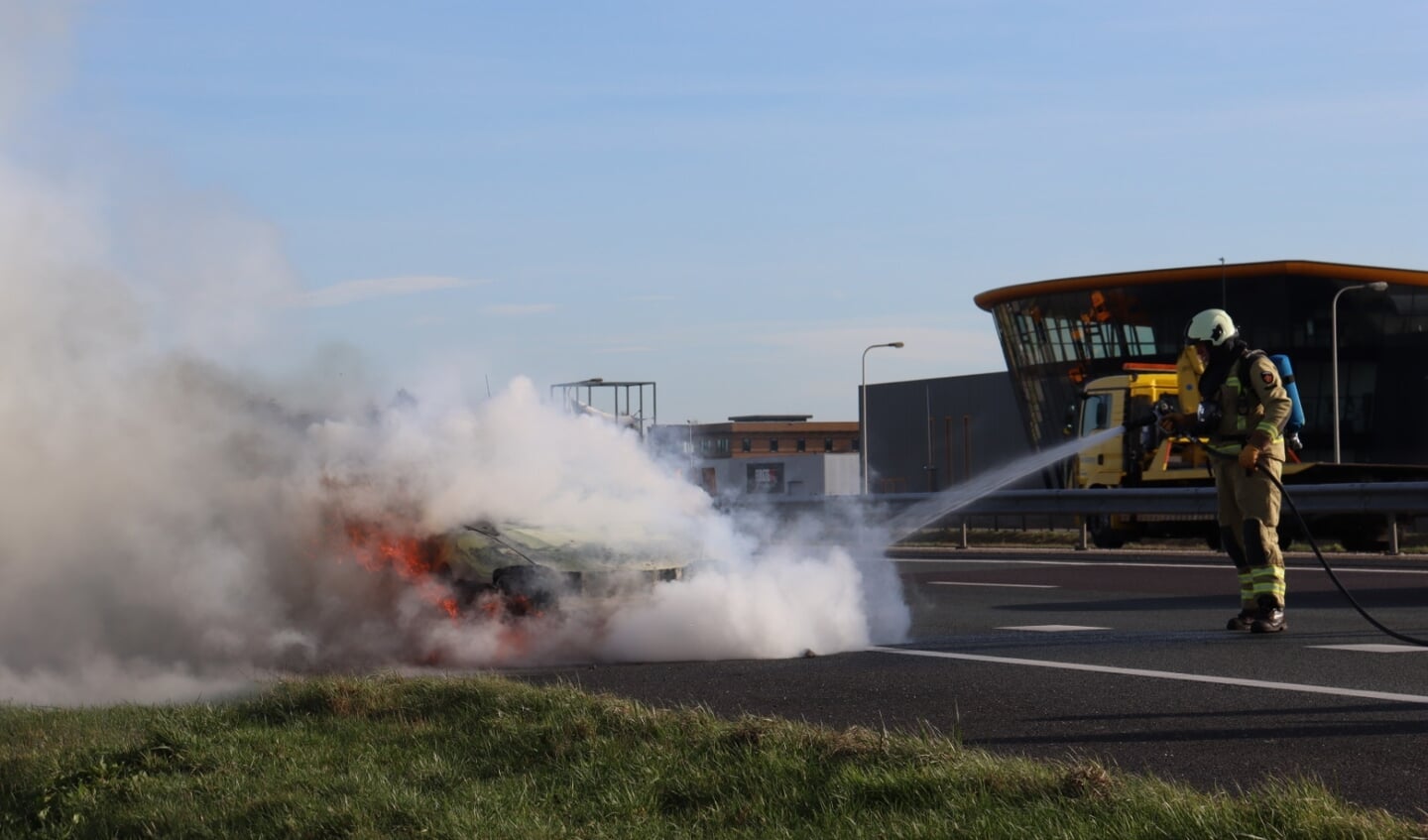 De brandweer blust de autobrand