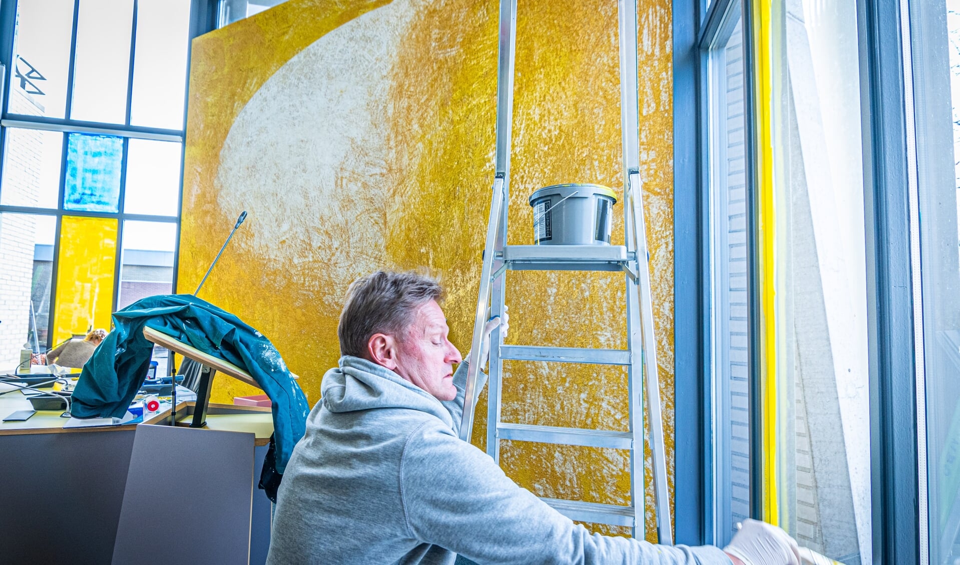 Gewapend met een kwast en een verfroller schilderen burgemeester Rob Bats en gemeentesecretaris Judith de Groot de ramen van de Raadszaal van het gemeentehuis in Steenwijk in de kleuren van de Oekraïnese vlag. 