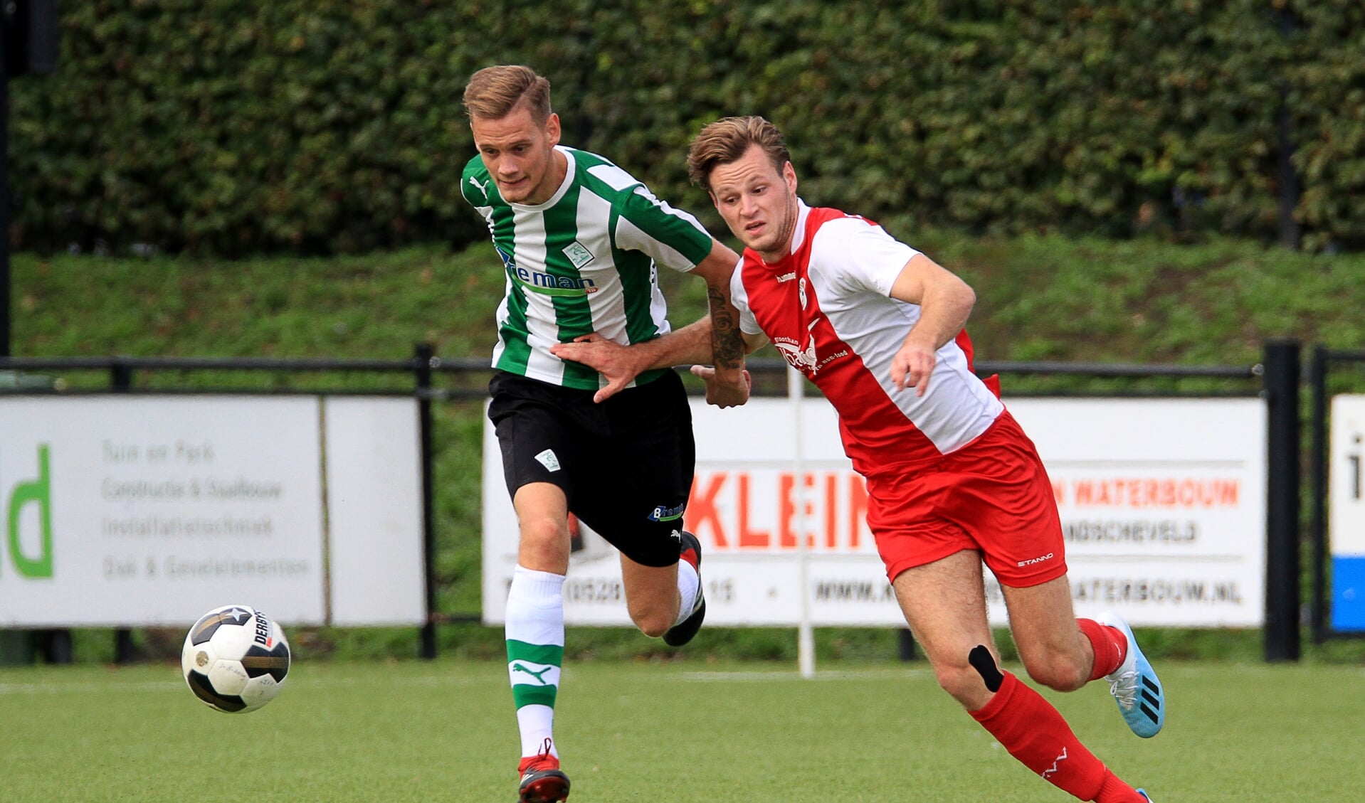 Yoran Popovic (r) in het shirt van HZVV in duel met Jens Jurn Streutker van Sportclub Genenuiden