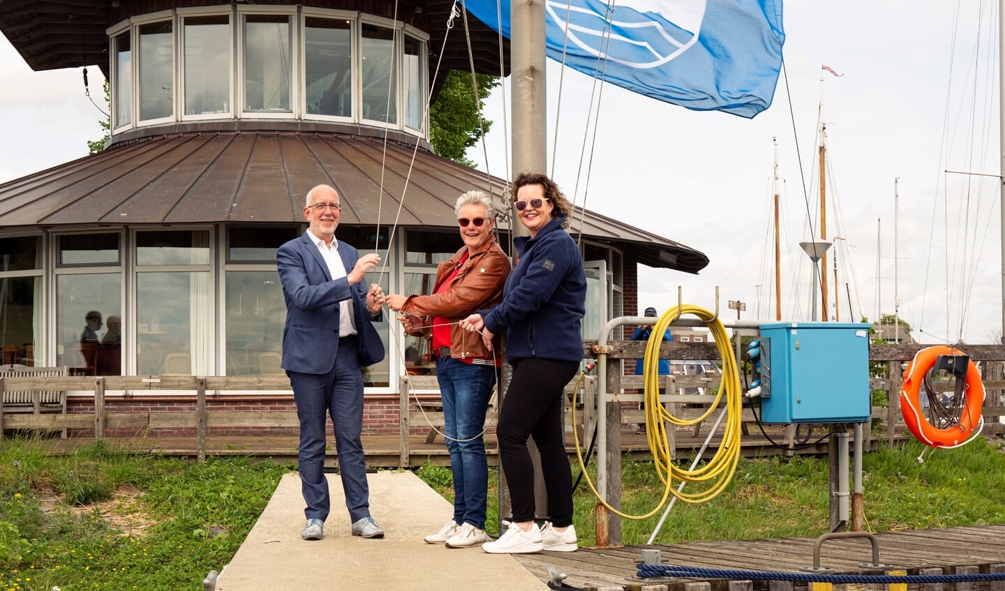 Gerrit Knol en Hilda Verwer en Annegreeth Steinbach hijsen een Blauwe Vlag.