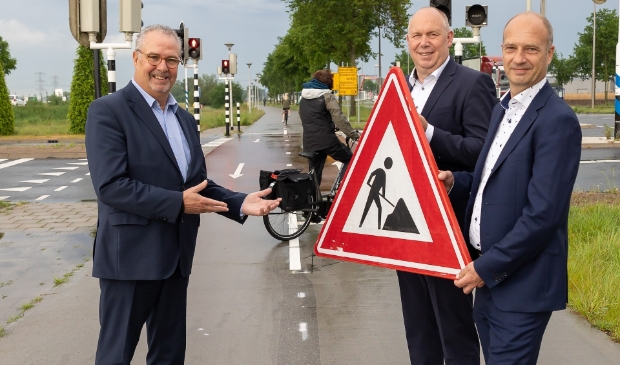 Wethouder William Dogger, gedeputeerde Bert Boerman en directeur mede-eigenaar NTP openen het fietspad aan de Nieuwleusenerdijk op bedrijventerrein Hessenpoort. 