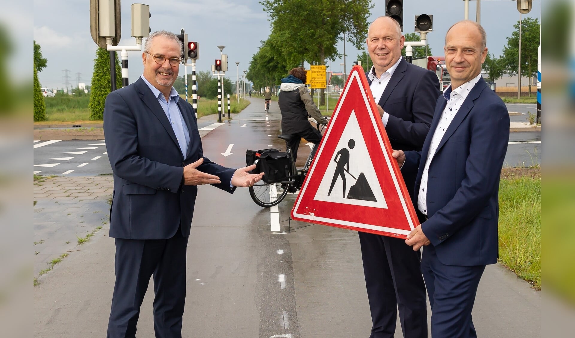 Wethouder William Dogger, gedeputeerde Bert Boerman en directeur mede-eigenaar NTP openen het fietspad aan de Nieuwleusenerdijk op bedrijventerrein Hessenpoort.