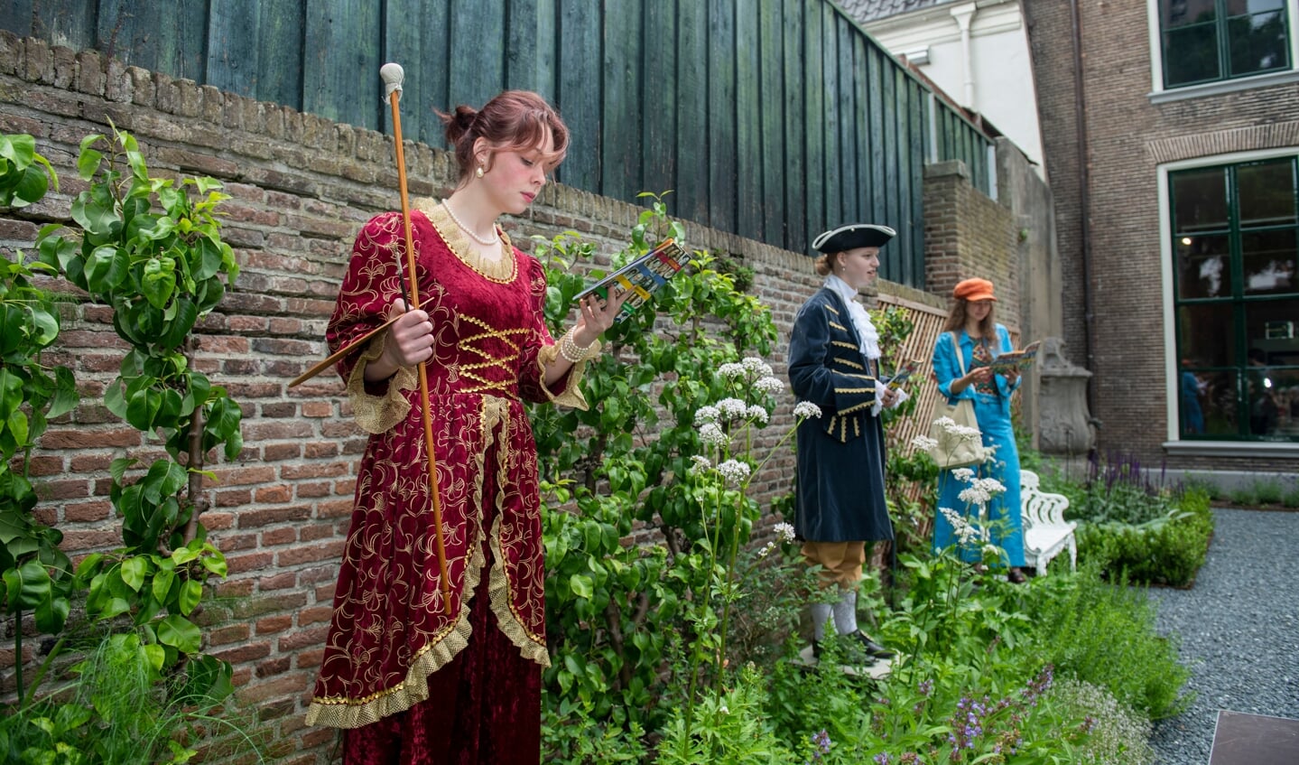 Aleida Greve, schilderes en stichtster van Het Vrouwenhuis, bekijkt het routeboekje van de Vrouwenwandeling.