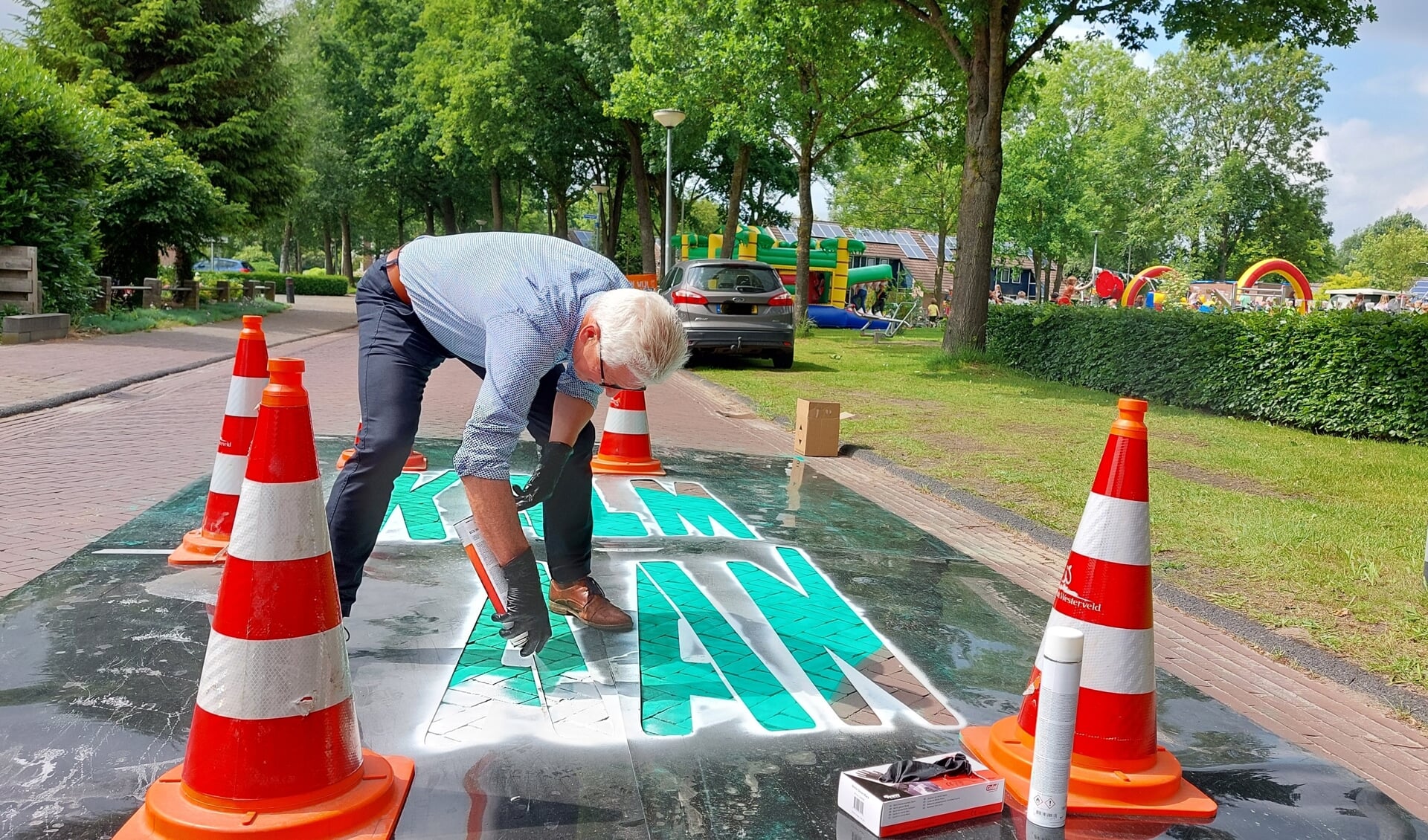 Wethouder Henk Doeven zette een boodschap voor de weggebruikers op het wegdek van het Kerkpad