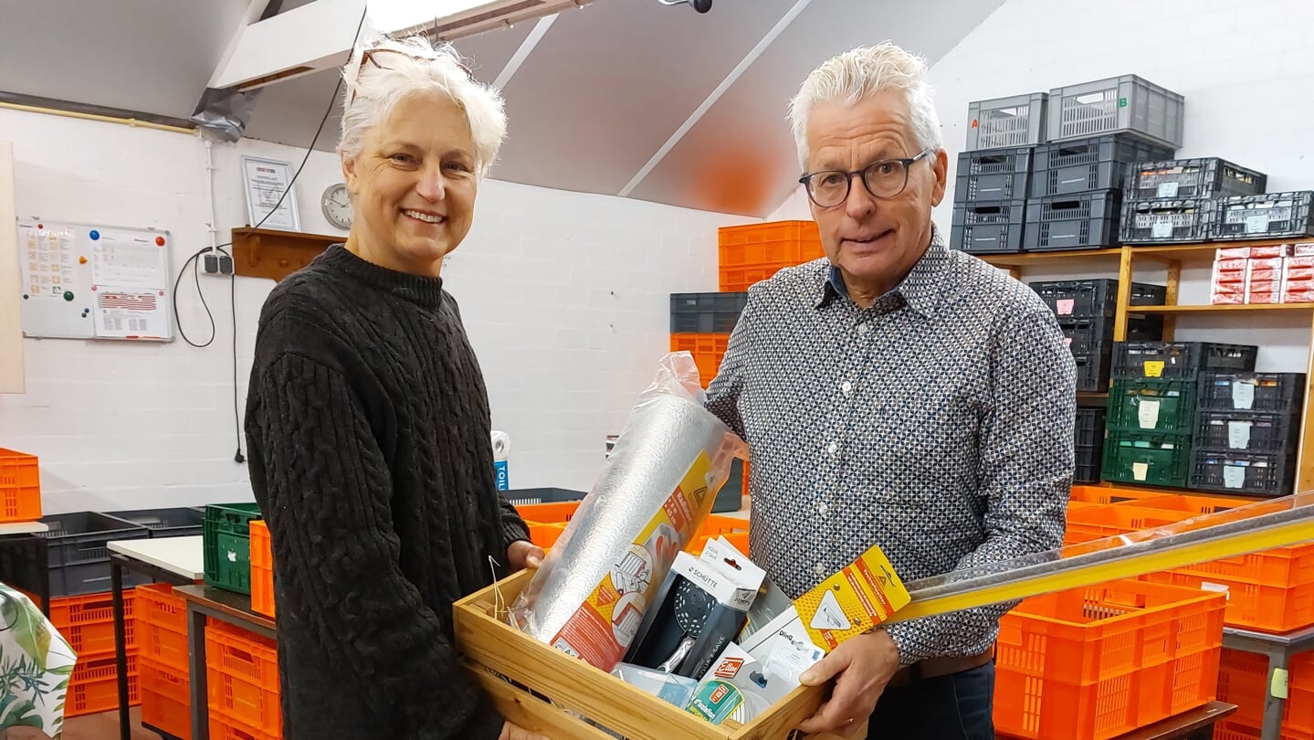 Wethouder Henk Doeven overhandigt een pakket met kleine besparende maatregelen over aan Alien Jalving, coördinator van de voedselbank Westerveld