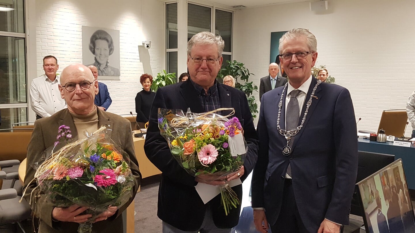 Hans Visser (l) en Hans de Groot kregen bij hun installatie een bloemetje van burgemeester Gorter.