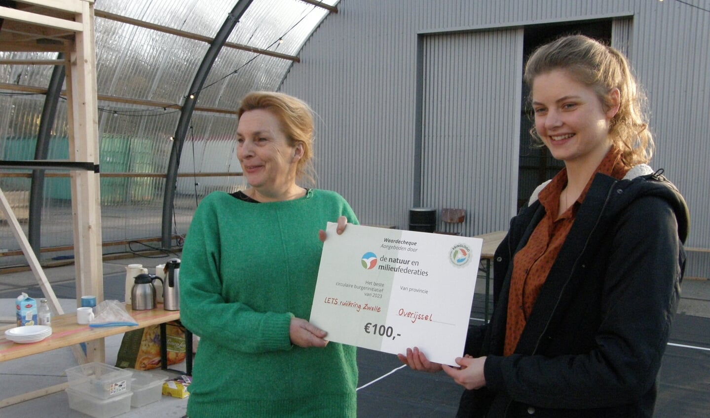 Voorzitter van LETS Zwolle Annelies Kalisvaart (l) neemt de Kringlogo cheque in ontvangst.