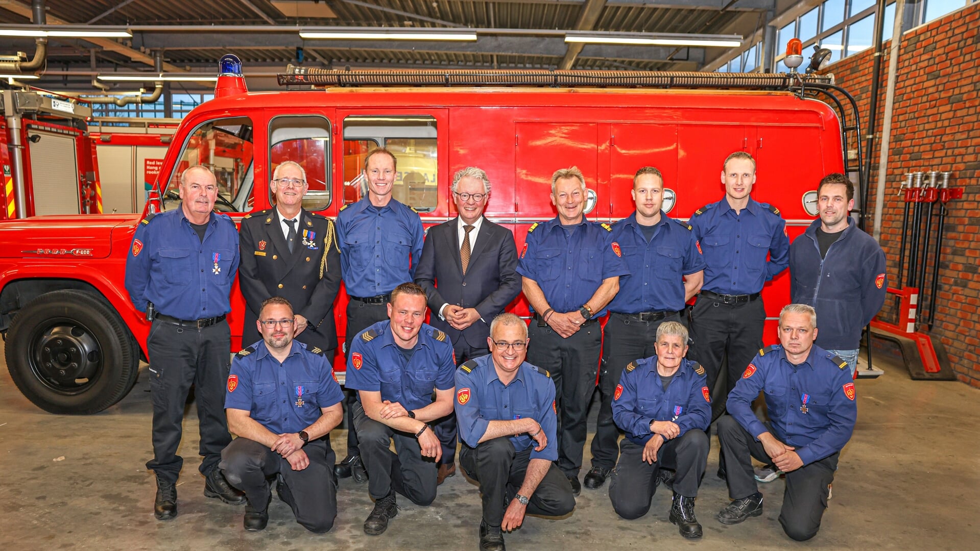 Rein van den Berg (staand uiterst links) bij zijn 35-jarig jubileum, samen met andere jubilarissen en diploma-behalers, burgemeester Gebben, brandweercommandant John van der Zwan en teamleider Roland Beekman.