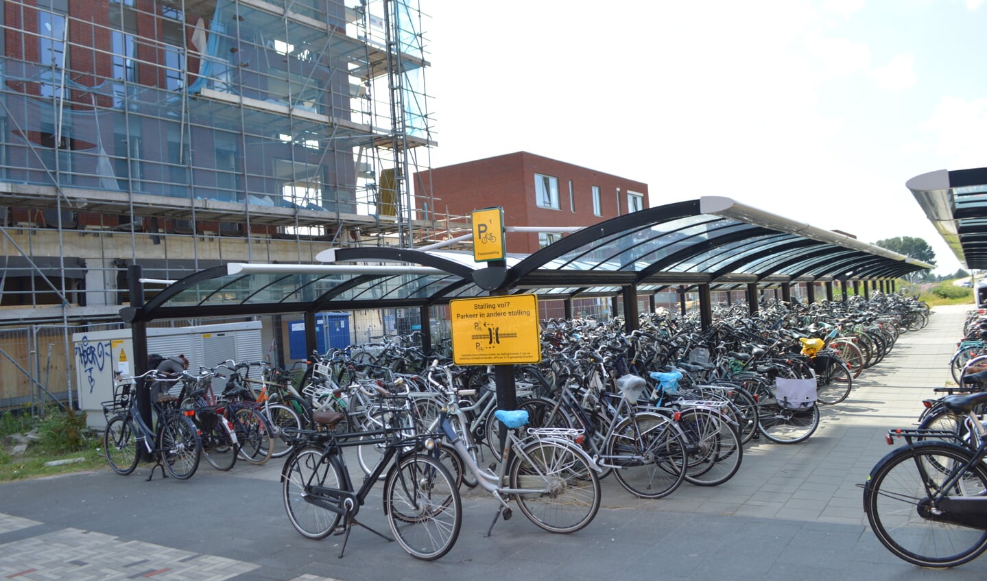 De fietsenstalling bij het station met links de nieuwbouw van appartementengebouw De Kroon.