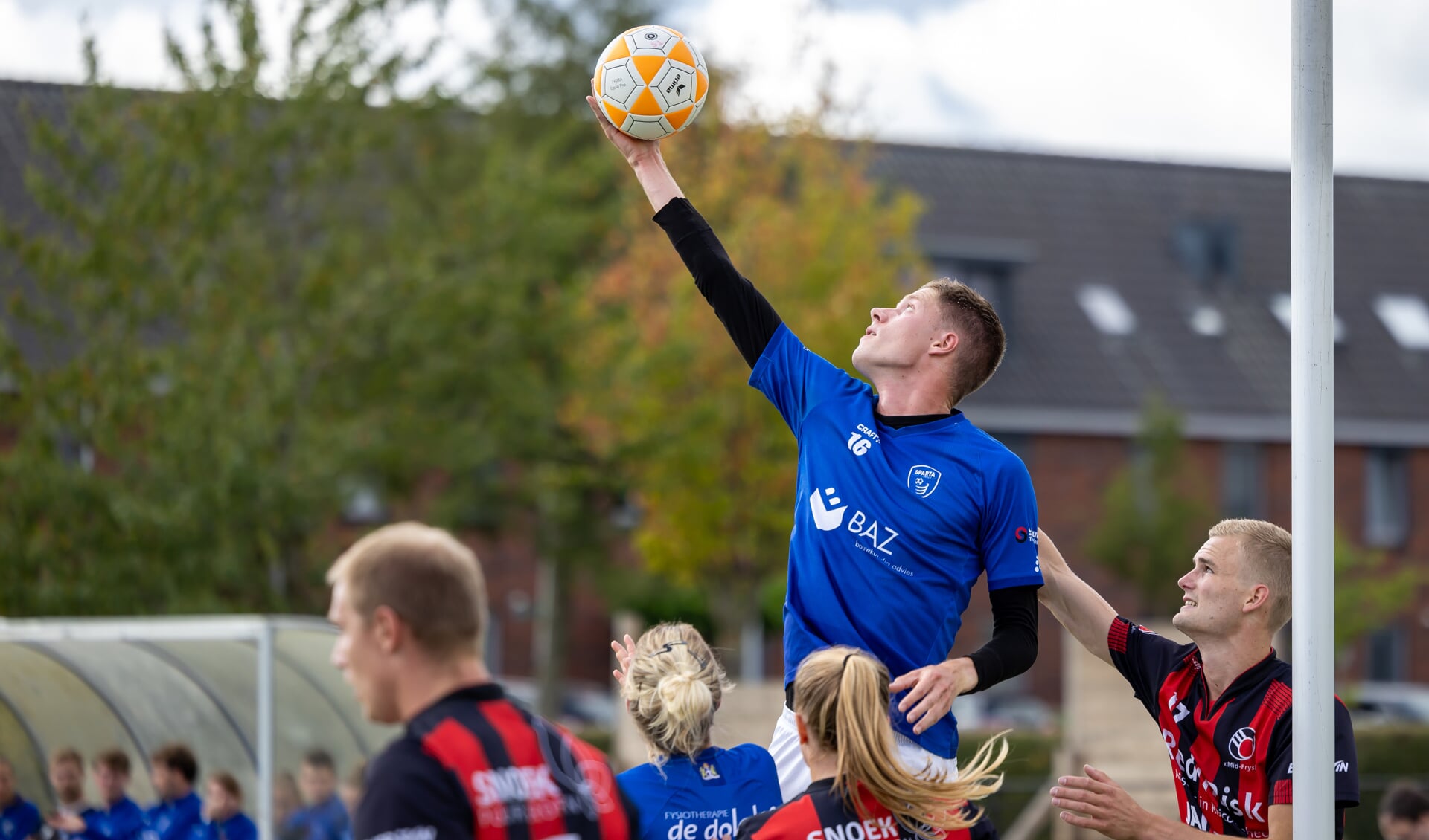 Spartaan Jesper Walinga torent hoog boven iedereen uit en heeft de bal.