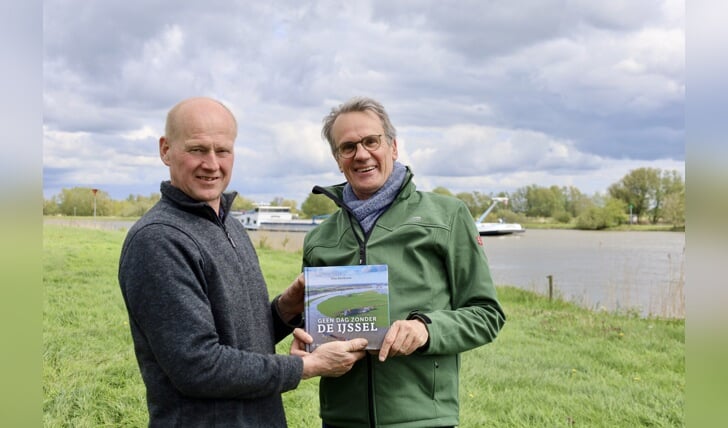 Roelof Marskamp krijgt het eerste exemplaar van de tweede druk van 'Geen dag zonder de IJssel' van schrijver Wim Eikelboom.