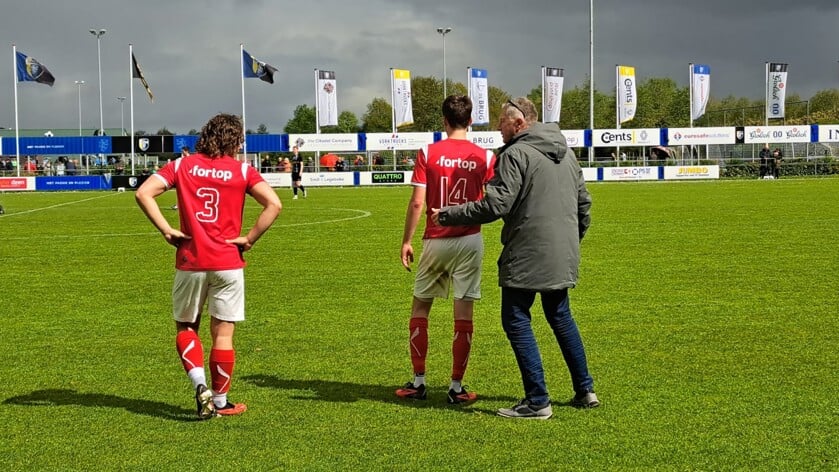 Tijdelijk trainer Bert Hendriks geeft Akkerman tijdens onderbreking instructies.