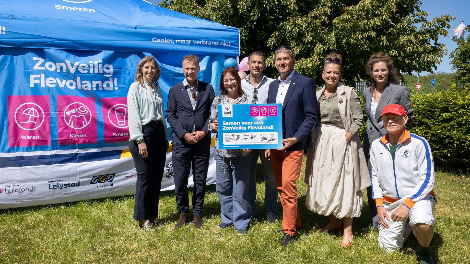 vlnr: Annemieke Messelink-Dijkstra, wethouder gemeente Lelystad, Freek Brouwer, wethouder gemeente Urk, Marijne Landman, directeur Nationaal Huidfonds, Matthijs Kamp, tennisvereniging ITL, Erik van de Beld wethouder Zeewolde, Lasize Hillebregt, wethouder gemeente Dronten, Simone Kukenheim directeur GGD Flevoland en een lid van de tennisvereniging.