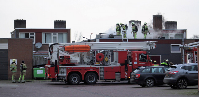 De brandweer in actie op het dak van de Chinees.